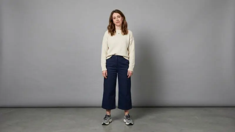 Mulher usando calça pantalona no comprimento errado (capri) e tênis contrastante, ilustrando erro de silhueta